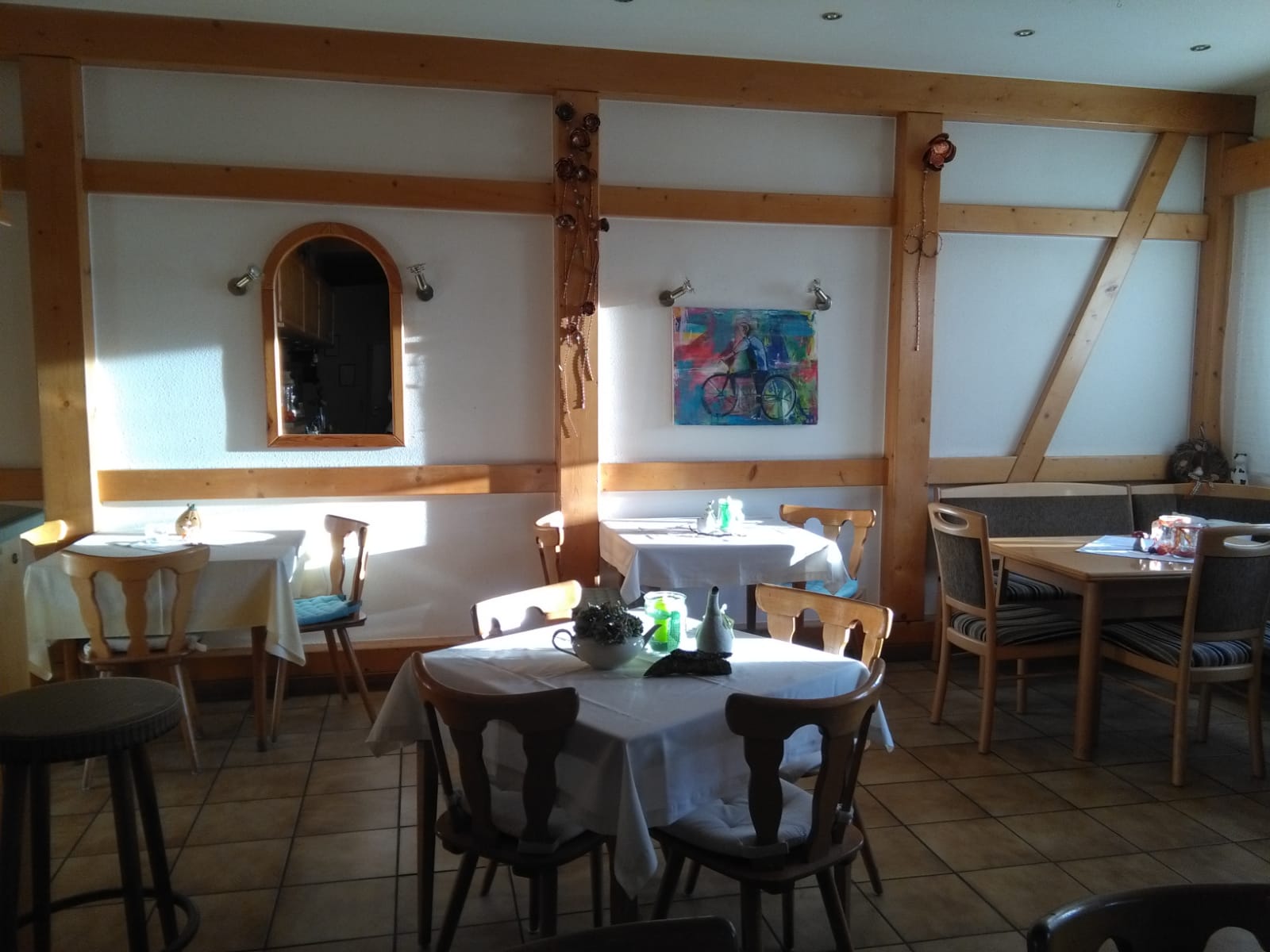 Gaststättenräum mit 3 Tischen, Holzstühlen und 1 Eckback. Eingedeckt mit Tischdecken und Deko auf dem Tisch. Gasthaus Sonntag in Bonndorf